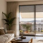 Operación Búnker: Cómo mantener tu casa fresca a 25°C sin arruinarte en aire acondicionado ¿Sientes que tu casa se convierte en un auténtico horno en cuanto aprieta el calor? Es frustrante ver cómo la factura de la luz sube sin control mientras tu aire acondicionado trabaja al máximo y, aun así, en cuanto lo apagas, el bochorno regresa. El error que comete la mayoría es intentar enfriar la casa cuando el calor ya está dentro. Los que llevamos más de dos décadas en esto sabemos que la clave no es enfriar, sino bloquear. Aquí tienes la estrategia definitiva para blindar tu hogar este verano y mantener una temperatura de confort digital sin que te cueste un riñón. El "Efecto Invernadero" doméstico: Por dónde entra el calor Antes de actuar, debes entender a tu enemigo. El sol golpea tus ventanas y el cristal multiplica ese calor hacia el interior. Si no tienes una barrera física exterior, estás vendido. Las persianas: Tu primera línea de defensa No todas las persianas protegen igual. Si tienes las típicas lamas de plástico deformadas por los años, el calor se filtra como si nada. Aluminio térmico con poliuretano: Son el estándar de oro actual. Estas lamas tienen un aislamiento interior que rompe el puente térmico, evitando que la radiación solar caliente la estancia. El color importa: Las lamas claras (blanco, gris plata, marfil) reflejan la luz; los colores oscuros la absorben y la irradian hacia dentro. Piénsalo antes de elegir estética sobre confort. Toldos: El escudo exterior Un toldo bien colocado en la fachada reduce la radiación solar que llega a tus cristales hasta en un 80%. Al crear un colchón de sombra exterior, impides que el vidrio alcance temperaturas extremas. Estrategia de Persianas: El despliegue inteligente Para lograr esa "Operación Búnker" y clavar el termómetro en los 25°C, tienes que gestionar tus persianas como un profesional: Fase de aislamiento (09:00 a 21:00): Baja las persianas de las fachadas donde pegue el sol directo. No hace falta que te quedes a oscuras; deja las lamas a medio activar (con las ranuras de ventilación abiertas) para que corra el aire pero no entre el rayo directo. Fase de ventilación cruzada (21:00 a 08:00): Abre por completo las persianas y las ventanas en fachadas opuestas. Así generas una corriente que expulsa el aire caliente acumulado en el techo y mete el aire fresco de la noche. 💡 El Consejo del "Viejo Lobo" de las Persianas Aquí va un truco de instalador veterano que te ahorrará cientos de euros y algún disgusto: Revisa los pasacintas y los cajones de tus persianas. > El 40% del calor del verano (y del frío en invierno) no entra por el cristal, sino por el hueco del cajón de la persiana si no está aislado, o por la ranura por donde pasa la cinta. Si notas aire caliente al acercar la mano a la cinta, compra una lámina de aislamiento termoacústico flexible (como el reflexivo o polietileno), abre el registro del cajón y fórralo por dentro. Es barato, lo haces en media hora y cambia radicalmente la temperatura de la habitación. Automatización: Deja que la domótica trabaje por ti Si pasas el día fuera de casa, es imposible gestionar las persianas manualmente según se mueve el sol. Aquí es donde entra la motorización inteligente. Instalar motores avanzados (como los sistemas Somfy con tecnología io-homecontrol) combinados con un sensor de sol en la fachada cambia las reglas del juego. Cuando el sensor detecta que el sol castiga la ventana, baja la persiana automáticamente. Cuando el sol se va, la sube. Llegarás a casa y la notarás fresca, sin haber encendido el aire en todo el día. Conclusión: Tu bolsillo lo notará Mantener tu casa fresca no depende de tener el aire acondicionado a 18°C las 24 horas del día. Depende de la inteligencia con la que uses tus persianas y toldos. Invierte en aislamiento exterior y la factura de la luz caerá en picado. ¿Tus persianas no bajan bien, están anticuadas o notas que entra fuego por el cajón? En Persianas Tosa nos encargamos de blindar tu hogar. Pídenos presupuesto sin compromiso y prepárate para pasar el verano más fresco de tu vida.